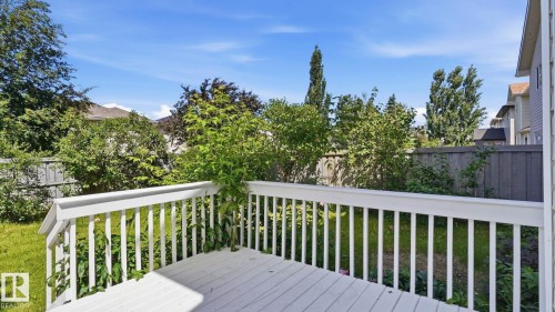 White painted wood deck with railing overlooking a fenced yard - 3591 Mclean Crescent, Edmonton, AB 