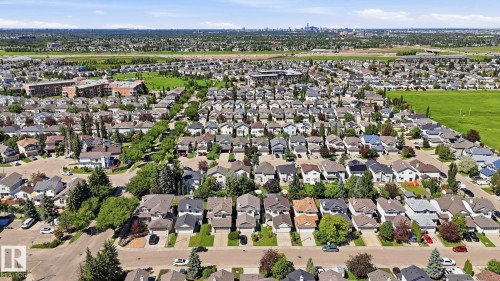 Expansive aerial perspective showcasing a residential neighborhood with numerous single-family homes, mature trees, and paved streets - 3591 Mclean Crescent, Edmonton, AB 