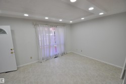 Recessed lighting in a tray ceiling, light-toned walls, and tile flooring - 