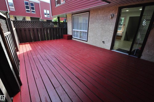 Expansive red-stained deck with slatted privacy fencing - 617 Millbourne Road E, Edmonton, AB 