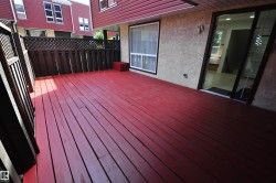 Expansive red-stained deck with slatted privacy fencing - 