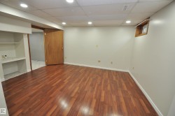 Spacious room featuring wood-finish flooring, recessed lighting, neutral wall paint, and white baseboards - 