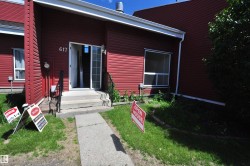 Red siding exterior featuring white trim and a concrete entry path - 