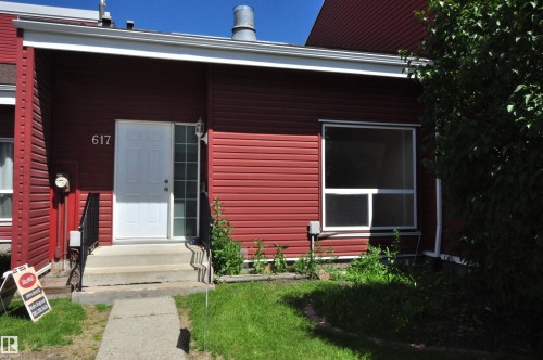 Red horizontal siding exterior with white trim, a white entry door, and a full-light sidelight - 617 Millbourne Road E, Edmonton, AB 