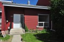 Red horizontal siding exterior with white trim, a white entry door, and a full-light sidelight - 617 Millbourne Road E, Edmonton, AB 