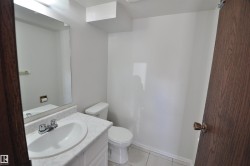 Bathroom featuring a white vanity with an integrated sink, polished chrome faucet, and a wall-mounted mirror - 
