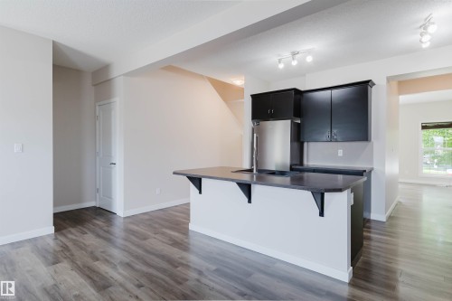 Kitchen island featuring dark countertops, a built-in sink, and sleek black cabinetry - 636 Mcdonough Link Link, Edmonton, AB 
