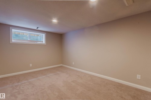 Carpeted room featuring a white-framed window with horizontal blinds, recessed lighting, and neutral wall tones - 636 Mcdonough Link Link, Edmonton, AB 