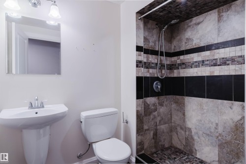 Bathroom featuring a pedestal sink, wall-mounted mirror, and a tiled shower enclosure - 636 Mcdonough Link Link, Edmonton, AB 