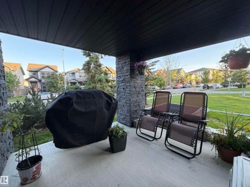 Front porch featuring a concrete surface, stone pillar accents, and a dark soffit ceiling - 114 1080 Mcconachie Boulevard, Edmonton, AB 