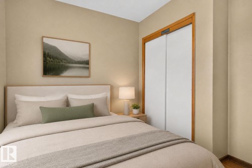 Bedroom featuring a light-colored headboard, neutral wall paint, and wood-finish flooring - 12238 48 Street, Edmonton, AB 