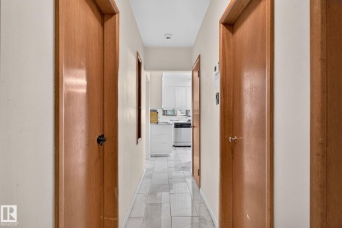 Hallway featuring light wood doors and light-colored walls - 12238 48 Street, Edmonton, AB 