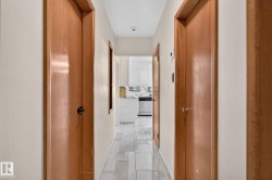 Hallway featuring light wood doors and light-colored walls - 