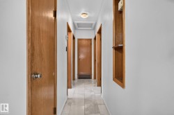 Hallway featuring light wood-finish doors and a recessed wall niche with shelving - 