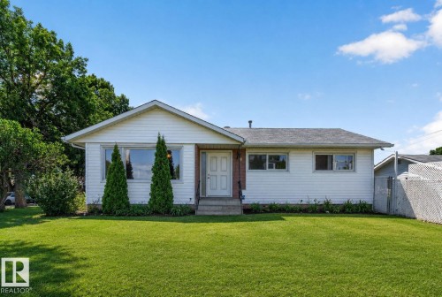 Single-story residence featuring white siding, a dark gray shingle roof, and a prominent front gable - 12238 48 Street, Edmonton, AB 