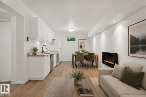 Open-concept living space featuring wood-finish flooring, recessed lighting, and a wall-mounted electric fireplace - 12238 48 Street, Edmonton, AB 