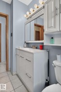 Bathroom vanity with a white countertop and base cabinetry featuring brushed nickel hardware - 