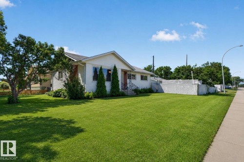 Expansive front yard with a lush green lawn and mature trees - 12238 48 Street, Edmonton, AB 