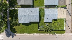 Aerial perspective of a property featuring a gray shingle roof and a spacious green lawn - 