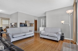Living area featuring wood-finish flooring, light gray wall paint, and white crown molding - 