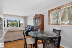 Open-concept living and dining area featuring warm wood-finish flooring - 