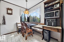 Dining area featuring a bay window, a built-in bench, and wood-finish flooring - 