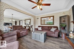 Spacious common area featuring wood-finish flooring and patterned wallpaper - 