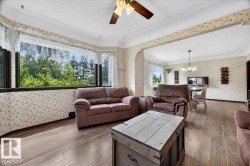 Living area featuring a wide bay window and wood-finish flooring - 