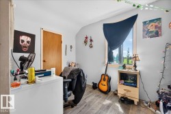 Interior room featuring light gray walls, wood-finish flooring, and a single window - 