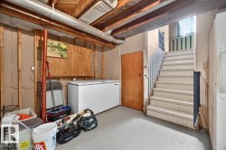Basement area featuring a painted concrete floor, exposed wood ceiling joists, and visible ductwork - 