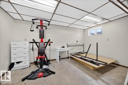 Room with drop ceiling, concrete flooring, and baseboard trim - 