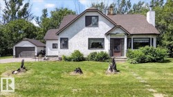 Stucco exterior residence featuring a prominent covered front entry, bay window, and a gabled roofline - 