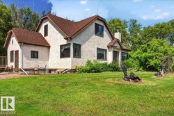 Stucco exterior with brown trim windows, a prominent front entrance, and a side deck - 