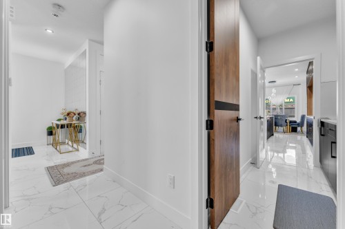 Entryway featuring white tile flooring with grey veining, white walls, and recessed lighting - 16816 49 Street, Edmonton, AB 