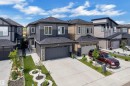 Contemporary two-story residence featuring a dark gray and light gray siding exterior with stone accents - 16816 49 Street, Edmonton, AB 