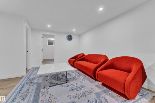 Spacious room featuring light wood-finish flooring, recessed lighting, and white walls - 16816 49 Street, Edmonton, AB 