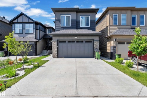 Contemporary two-story exterior featuring a grey and dark blue façade with stone accents - 16816 49 Street, Edmonton, AB 