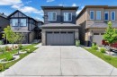 Contemporary two-story exterior featuring a grey and dark blue façade with stone accents - 16816 49 Street, Edmonton, AB 