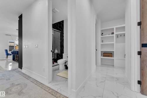 Hallway featuring light-toned tile flooring and recessed lighting - 16816 49 Street, Edmonton, AB 