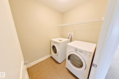 Dedicated laundry space featuring ceramic tile flooring and a neutral wall color - 4343 Crabapple Crescent, Edmonton, AB 