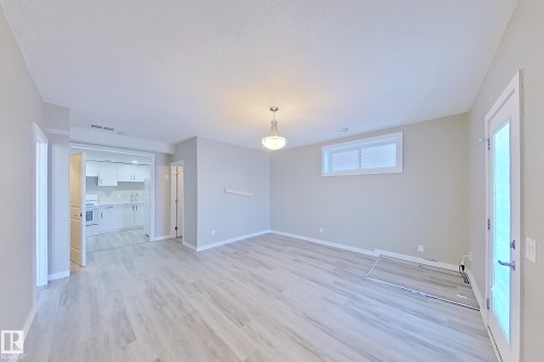 Open-concept living area featuring light wood-finish flooring and neutral wall tones - 4343 Crabapple Crescent, Edmonton, AB 