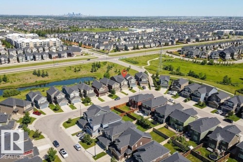 Aerial view showcasing a residential neighborhood with detached homes, a central urban corridor, and distant city skyline - 4343 Crabapple Crescent, Edmonton, AB 