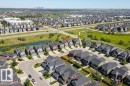 Aerial view showcasing a residential neighborhood with detached homes, a central urban corridor, and distant city skyline - 4343 Crabapple Crescent, Edmonton, AB 