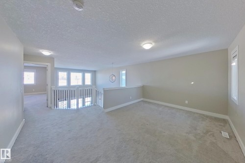 Expansive upper-level landing featuring light grey carpeting and neutral wall tones - 4343 Crabapple Crescent, Edmonton, AB 