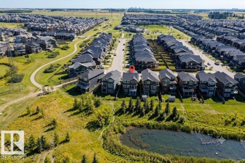 Aerial perspective showcasing a residential area with a prominent pond and green spaces - 4343 Crabapple Crescent, Edmonton, AB 