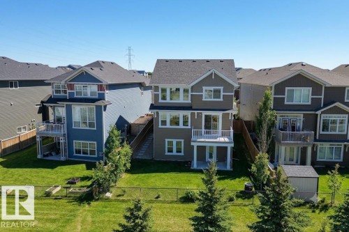 Two-story home featuring a spacious backyard, a second-story balcony, a ground-level patio, and a privacy fence - 4343 Crabapple Crescent, Edmonton, AB 