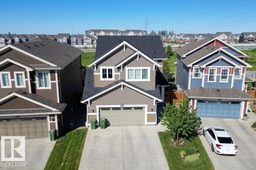 Two-story residence featuring a neutral-toned exterior with white trim and a dark shingled roof - 4343 Crabapple Crescent, Edmonton, AB 