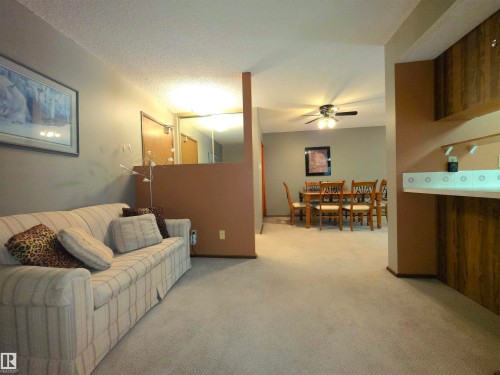 Carpeted living area with textured ceiling and neutral wall tones - 302 10335 118 Street, Edmonton, AB 