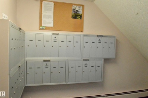 Wall-mounted mailboxes with individual locks, a cork bulletin board, and a baseboard heating unit - 302 10335 118 Street, Edmonton, AB 