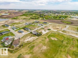Aerial perspective showcasing a residential development with established homes and undeveloped lots - 
